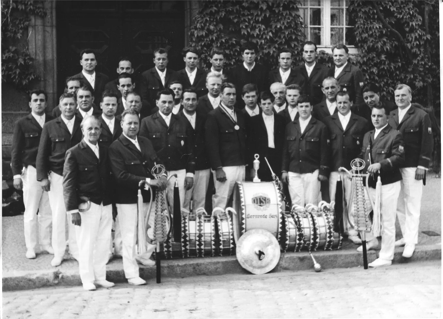 Historisches Schwarz-Weiß-Bild der Spielleute mit Instrumenten und Pokal